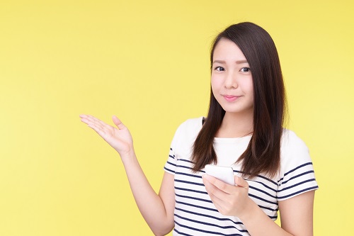スマホを持って説明する女性